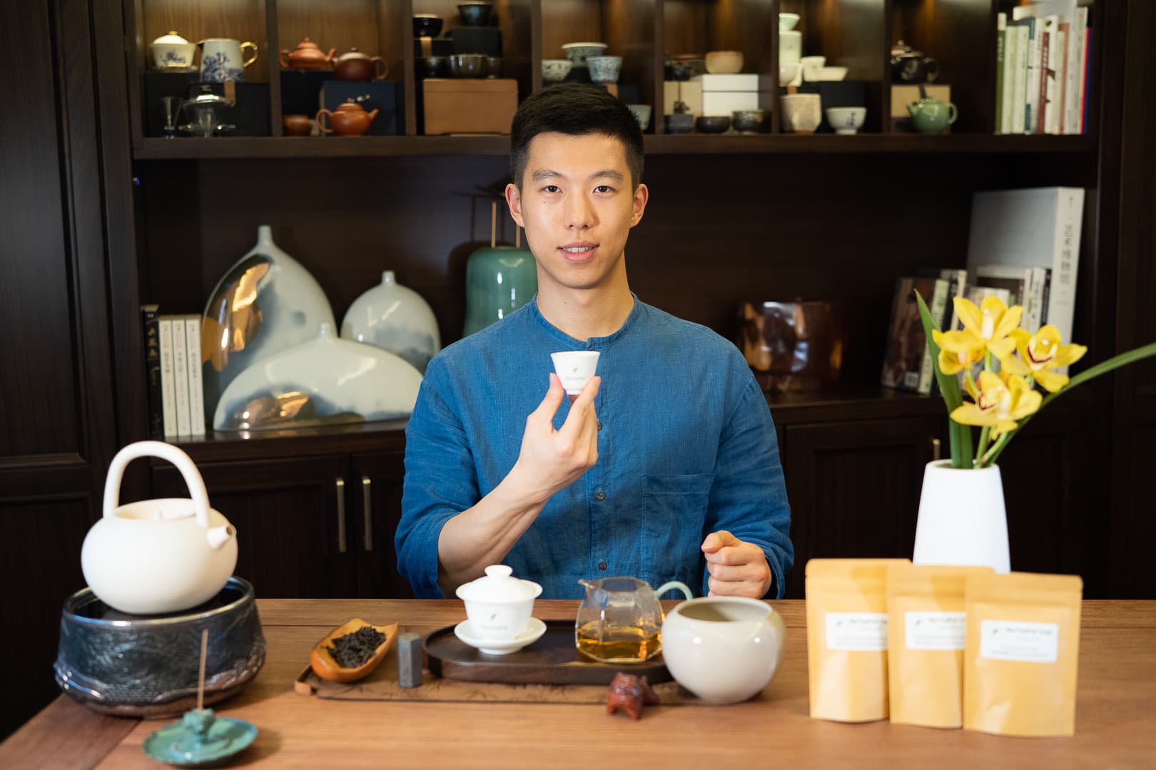 Vincent Liu raising a tasting cup beside a tea table